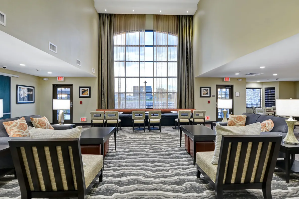 A stylish lounge area bathed in natural light, with comfortable seating, decorative pillows, and modern coffee tables. The space is arranged to encourage relaxation, socializing, or casual work.